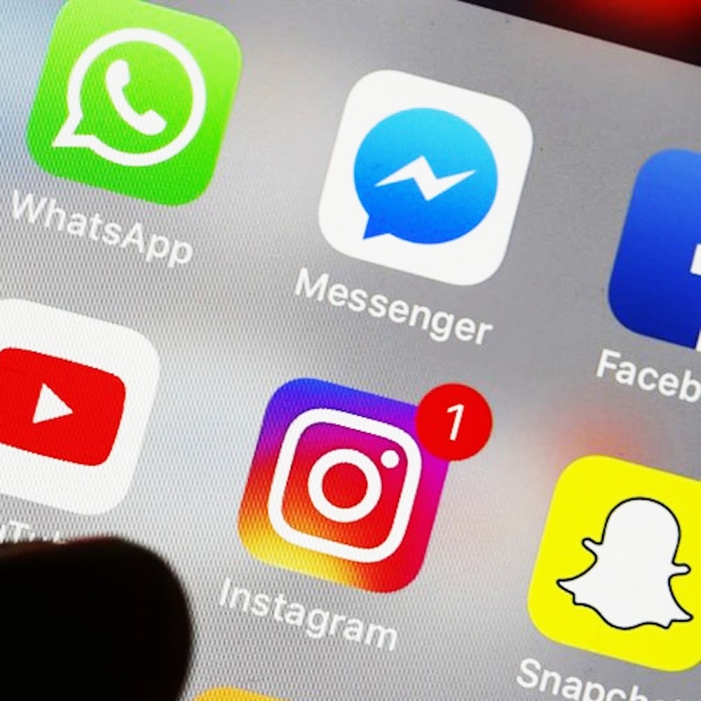 A smartphone screen displays popular social media app icons, including WhatsApp, Messenger, Facebook, YouTube, Instagram with a notification badge, and Snapchat—hinting at the impact of a Social Media Ban in Australia. A finger hovers near the bottom left corner.