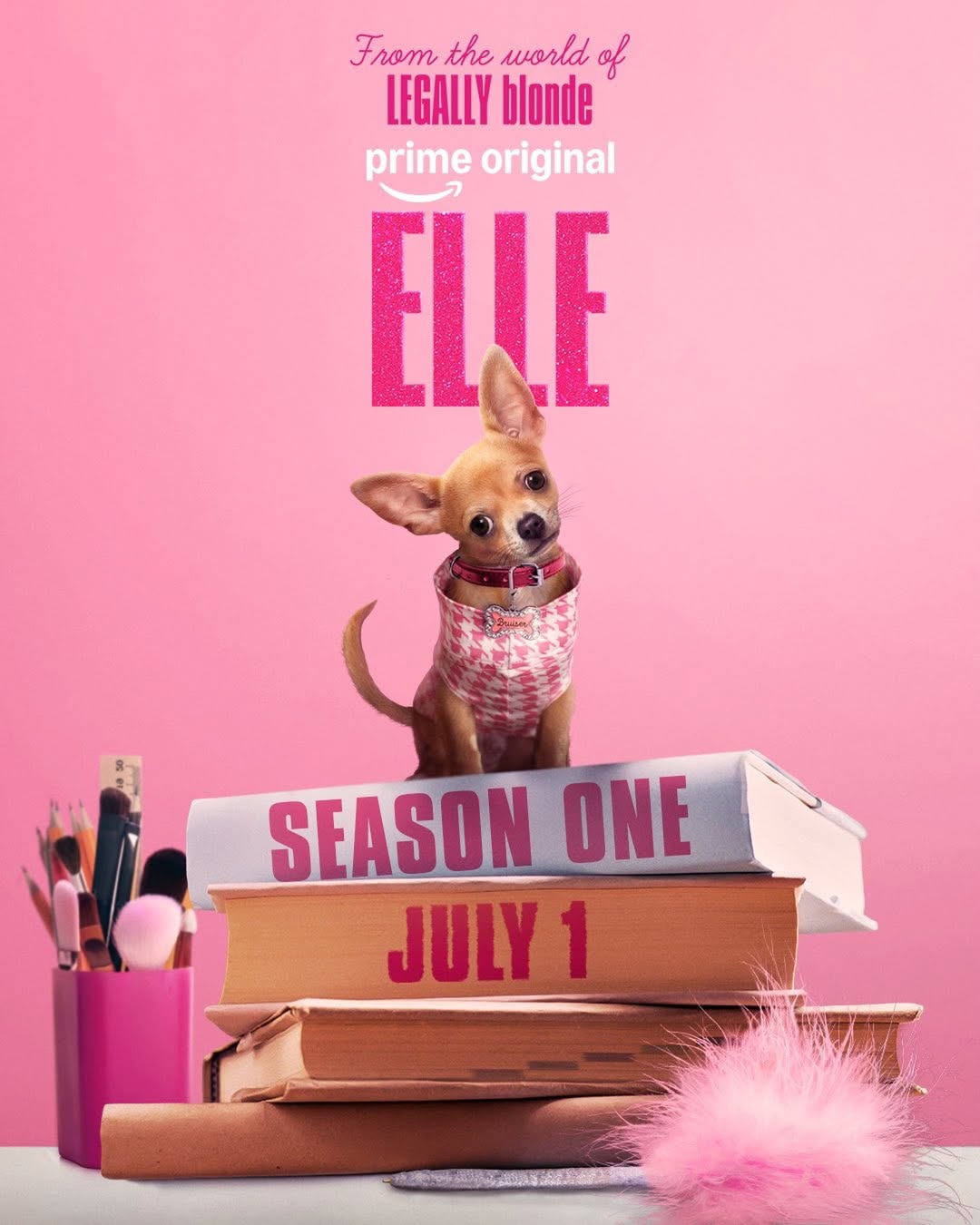 A small dog in a pink outfit stands on books labeled Season One and July 1, with makeup brushes and a pink fluffy item nearby. Text above reads, From the world of Legally Blonde prequel, Prime Original, Elle series.