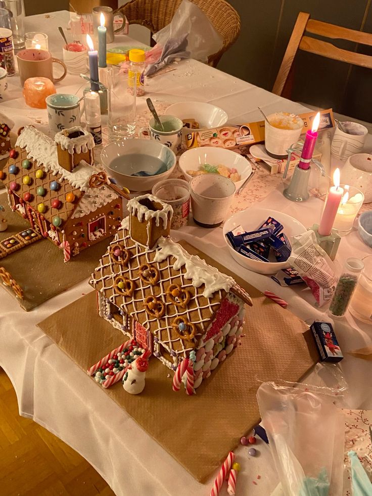 A festive table covered with gingerbread houses, colorful candies, and icing—alongside the chaos of decorating supplies and mugs—captures the joyful holiday spirit mixed with a dash of holiday family drama.