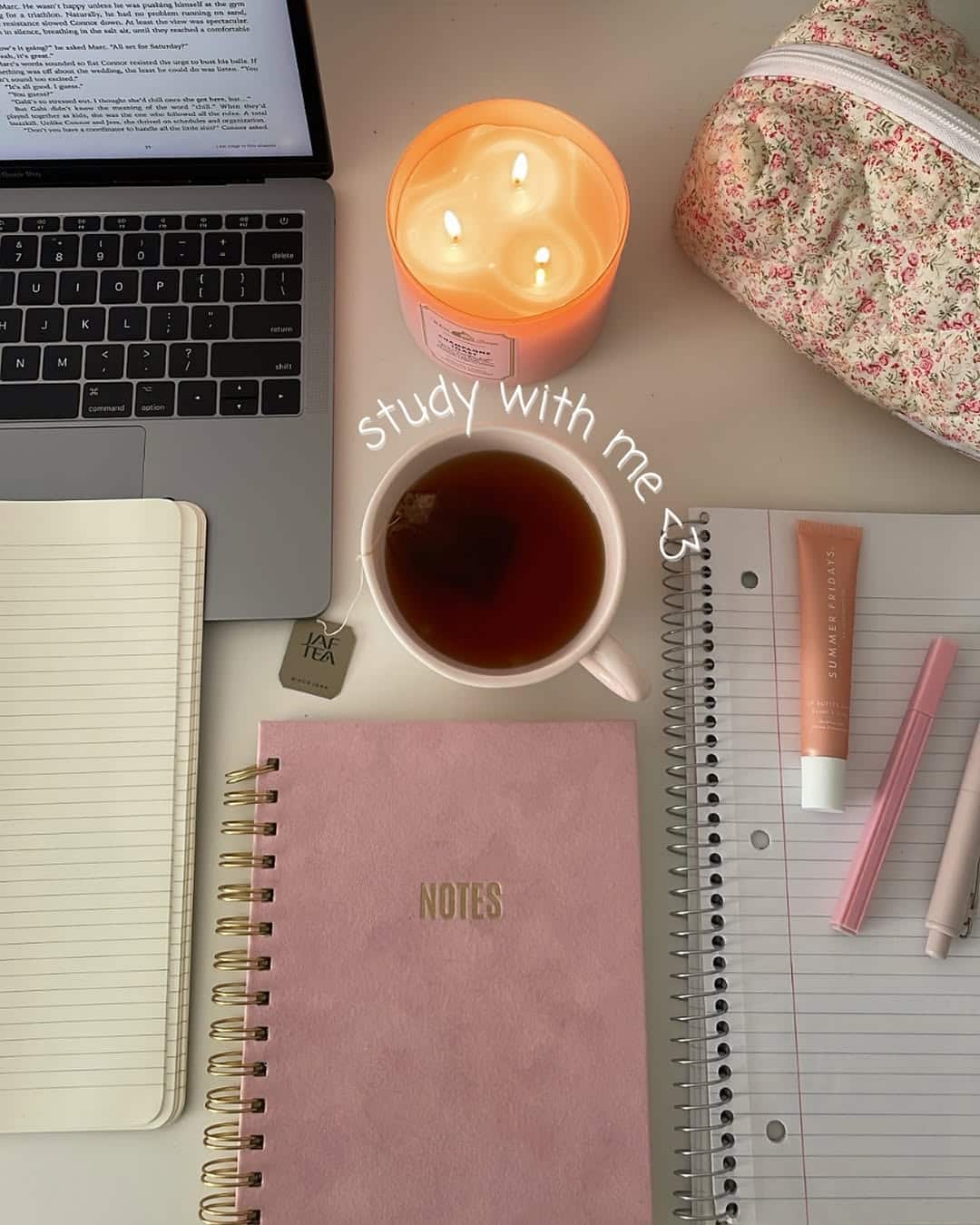 A cozy study setup with a laptop, pink candle, cup of tea, floral pouch, notebooks, pens, and lip balm on a desk—perfect for your after-school routine. The text “study with me <3” is written above the candle and tea.