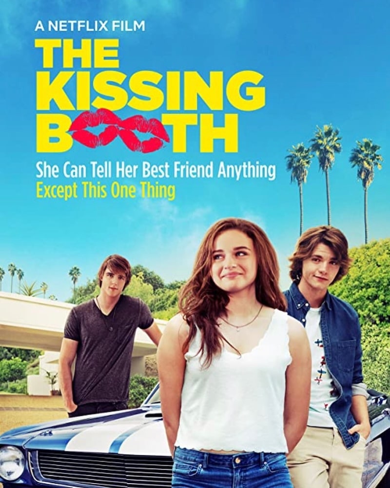 Poster for “The Kissing Booth,” inspired by Wattpad novels, shows a smiling teenage girl standing in front of a blue car with two boys. Palm trees and a clear sky are in the background, with bold yellow and white text highlighting this fun Rom Com.
