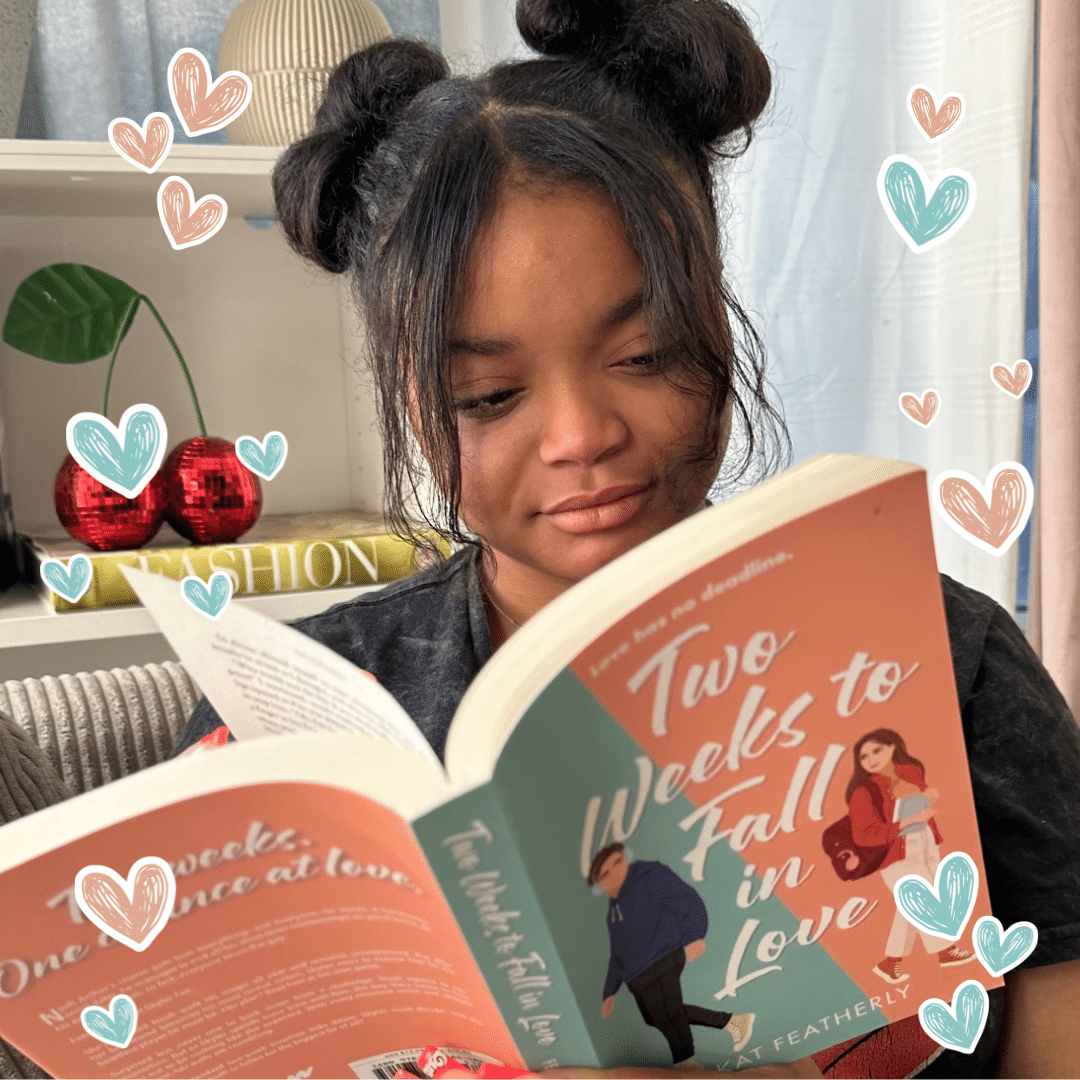 A woman with two space buns reads Two Weeks to Fall in Love on a couch. Illustrated hearts, a plant, and a red disco ball set the scene—perfect for anyone navigating breakups or dreaming about new boyfriends.
